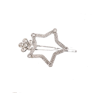 Détail d'une pince à cheveux étoile argentée avec motif évidé et strass scintillants