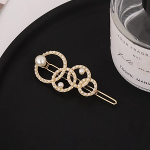 Barrette dorée élégante avec cercles superposés et perles d'imitation blanches