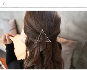 Minimalist gold hollow triangle metal hair clip shown on a half-up hairstyle