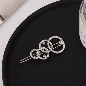 Détail de la pince à cheveux argentée avec cercles superposés, cristaux et perles fines