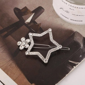 Pince à cheveux en forme d'étoile avec strass étincelants et perles sur un magazine