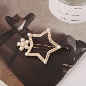 Barrette en forme d'étoile avec monture dorée et perles blanches sur magazine vintage