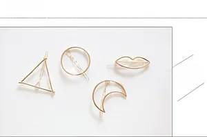Detail view of four minimalist geometric hair clips in shiny gold metal finish