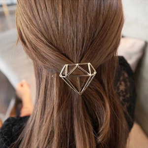 Minimalist geometric gold metal hair clip in diamond shape on brown hair