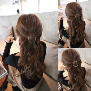 Minimalist gold alloy circular hair clip styled on elegant wavy brown hair back view