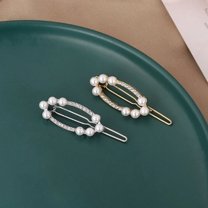 Elegante goldene und silberne Haarspangen mit Perlen und Kristallen auf grünem Tablett