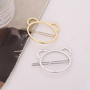 Minimalist hollow bear head metal hair clips in gold and silver finish set on white surface