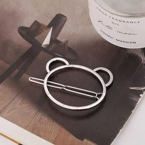 Detailed close-up of a silver hollow bear head hair clip on an aesthetic magazine layout