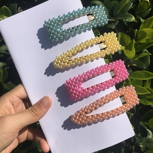 Set di quattro fermagli per capelli con perle colorate in blu, giallo, rosa e arancione