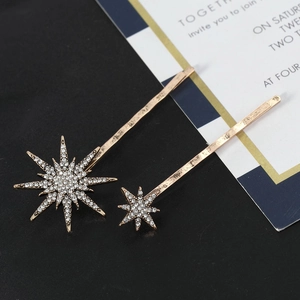 Elegante set di fermagli per capelli a stella dorata con strass scintillanti su sfondo