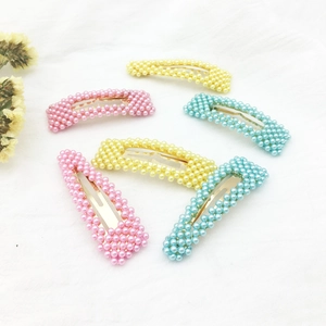 Set di fermagli per capelli con perle pastello in rosa, giallo e blu su tessuto