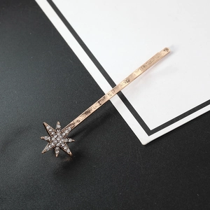 Set di forcine a stella in oro rosa con cristalli lucenti su sfondo minimalista bicolore
