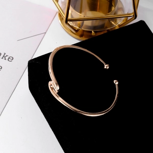 Bracelet jonc ouvert vague en or rose avec billes polies sur velours noir élégant