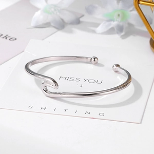Détail d'un bracelet jonc argenté à vagues avec billes sur un fond floral décoratif élégant