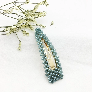 Dettaglio dell'elegante fermaglio per capelli BB con perle blu morandi su base oro