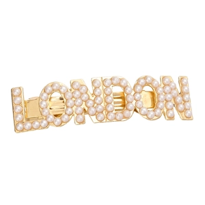 Barrette dorée avec lettres London et perles incrustées sur un fond blanc épuré