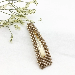 Dettaglio del fermaglio per capelli con perle champagne e base in lega dorata