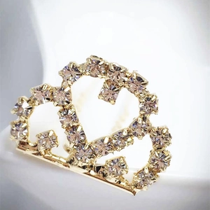 Vue macro d'un peigne à cheveux couronne dorée avec strass brillants pour mariées