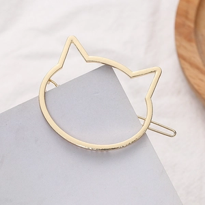 Detailopname van een katvormige gouden metalen haarclip met een gepolijste afwerking
