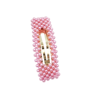 Elegante fermaglio per capelli con perle rosa e base in metallo dorato lucido