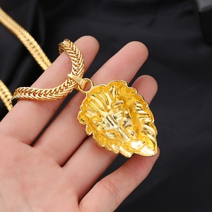 Detailaufnahme eines goldenen Löwenkopf-Anhängers mit einer massiven Hip-Hop-Weizenkette