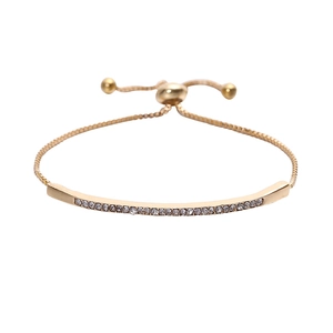 Adjustable gold bolo bracelet with sparkling rows of inlaid crystals on white background