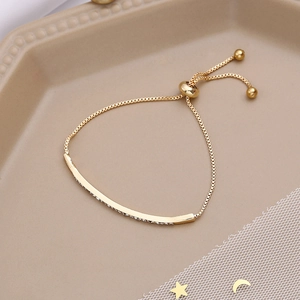 Detail of adjustable gold-plated slider bracelet with micro-pave crystals on metal bar