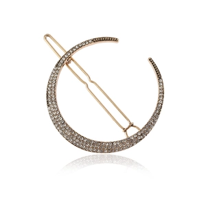 Sparkling gold crescent moon hair clip with pave set rhinestones on a mirror surface