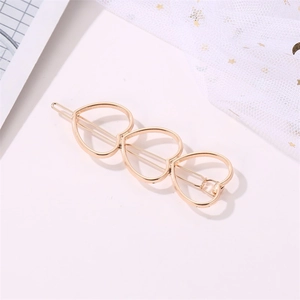 Close-up of golden hollow heart hair clip with elegant metal texture and lace backdrop