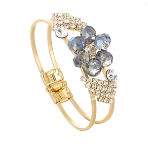 Detail of gold double-layer bracelet featuring blue crystals and pavé rhinestones