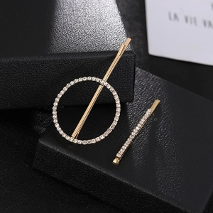 Ensemble de pinces à cheveux géométriques dorées avec strass brillants sur fond texturé