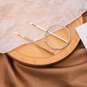 Détail de l'ensemble de deux barrettes dorées en strass avec motifs ronds et droits