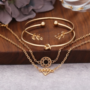 Détail du bracelet manchette feuille dorée et bijoux à nœuds dans un ensemble 4 pièces