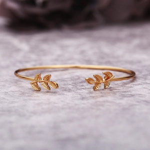 Vue macro du motif de feuille dorée sur bracelet réglable avec fond en marbre