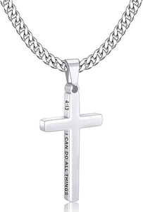 Close-up of polished cross pendant with engraved side text on a silver Cuban chain