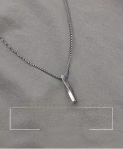 Detail view of a twisted silver cylinder pendant on a sleek bead chain in hip hop style