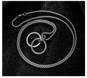 Close-up of interlocking double circles pendant on a stainless steel box chain necklace
