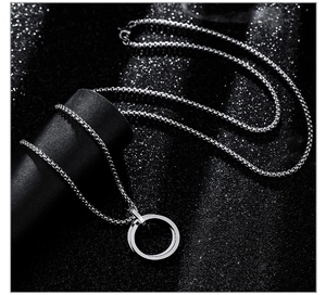 Macro detail of intertwined silver double ring pendant on sleek metal box chain