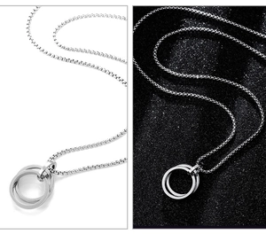 Detail of silver double interlocking rings pendant with box chain on dark background