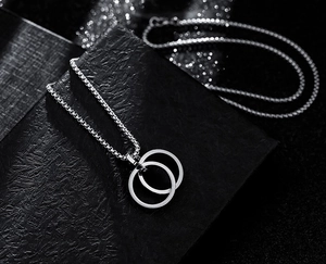 Detail of interlocking double rings pendant on a box chain with shimmering light spots