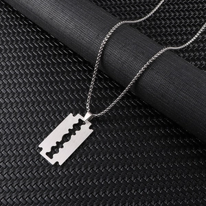 Macro shot of stainless steel razor blade pendant with brushed metal finish on a box chain