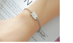 Détail du bracelet cœur en acier inoxydable argenté avec gravure ST ENDS sur plaque