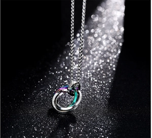 Détail du pendentif à trois anneaux imbriqués en argent et tons irisés sur chaîne