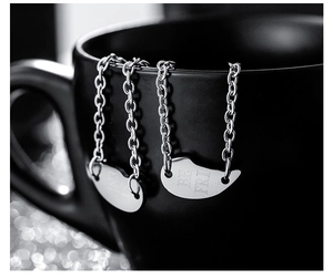Vue macro de pendentifs cœur en argent sur tasse noire avec gravure Best Friends polie