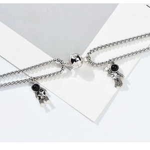 Detail of magnetic astronaut pendants on silver chain showing heart magnetic connection