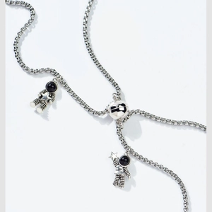 Macro shot of magnetic astronaut pendants on silver chain showing metallic details