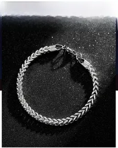 Detailed close-up of a silver titanium steel chain bracelet with a lobster clasp