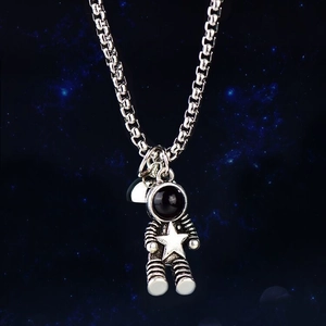 Detailed close-up of a silver astronaut pendant with black visor and star emblem on a chain