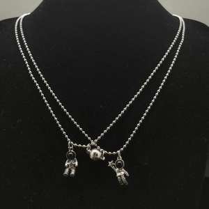 Close-up of magnetic astronaut couple necklaces with silver pendants on velvet display