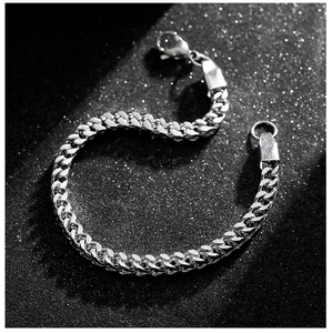 Macro detail of silver-tone stainless steel curb chain bracelet with lobster clasp